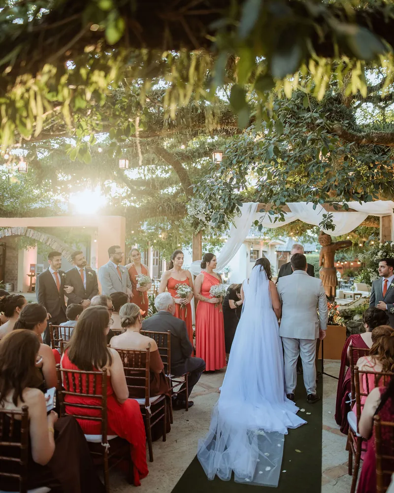 Cerimônia de casamento sob a figueira, com madrinhas de vermelho