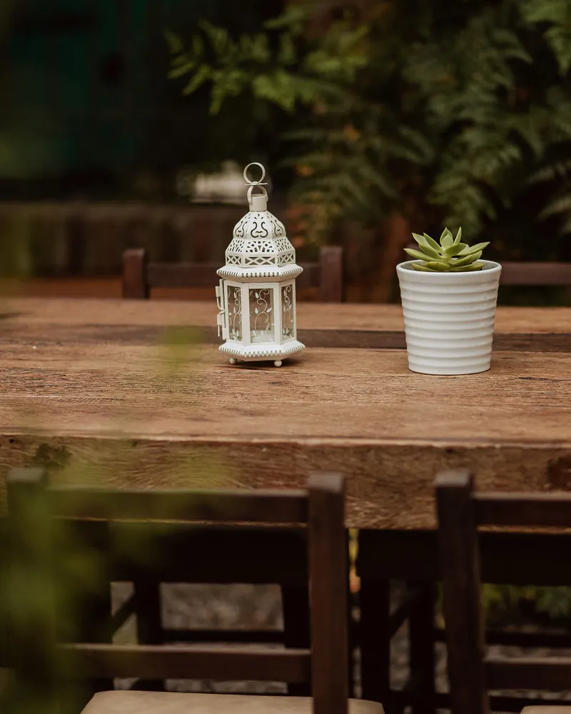 Mesa no jardim com lanterna e vaso de suculenta